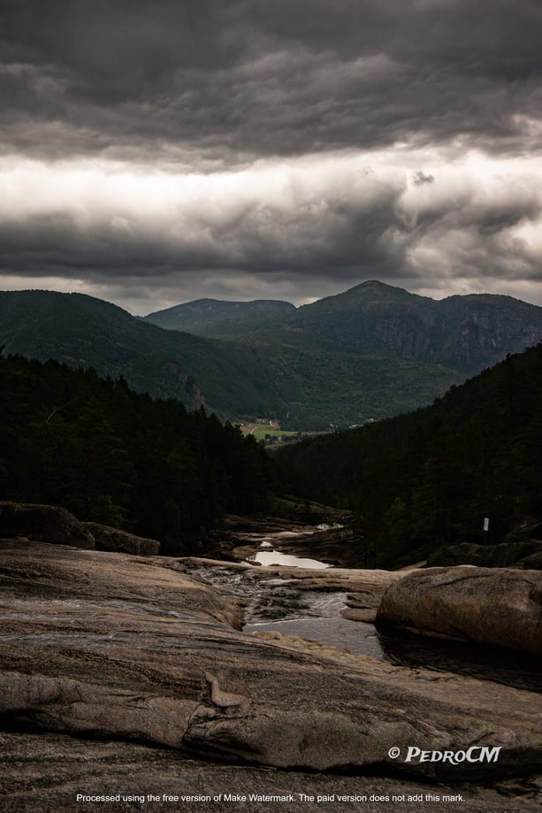 a view of the mountains and river under a cloudy sky